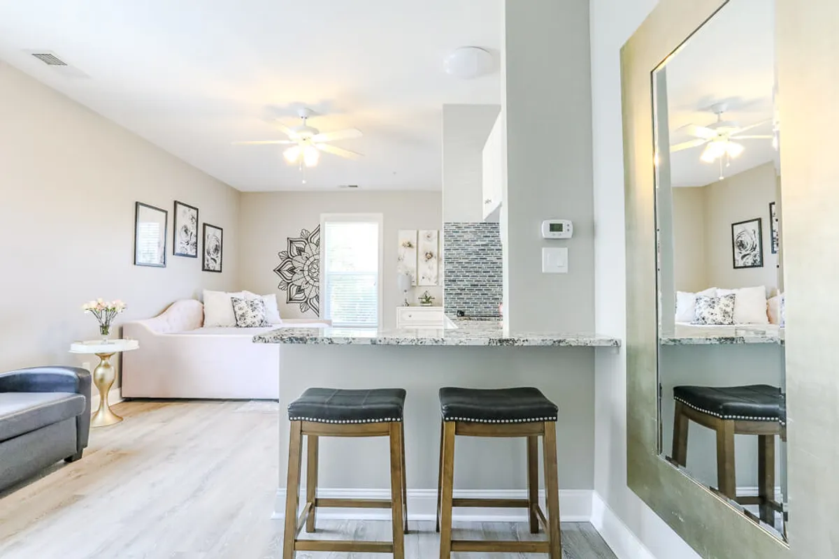 This image features a welcoming kitchen island with bar stools, decorative wall art, and a plush sofa with cushions. The layout encourages both casual dining and relaxing together—an ideal hub for families planning their next adventure or winding down after a fun-filled day.
